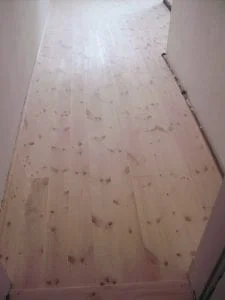 neuer Holzfußboden aus Kiefer-Dielenbrettern in einem Altbau. Dielung aus Nut-Feder-Brettern - oberflächenfertig lackiert und umlaufend mit Fußleisten versehen.
